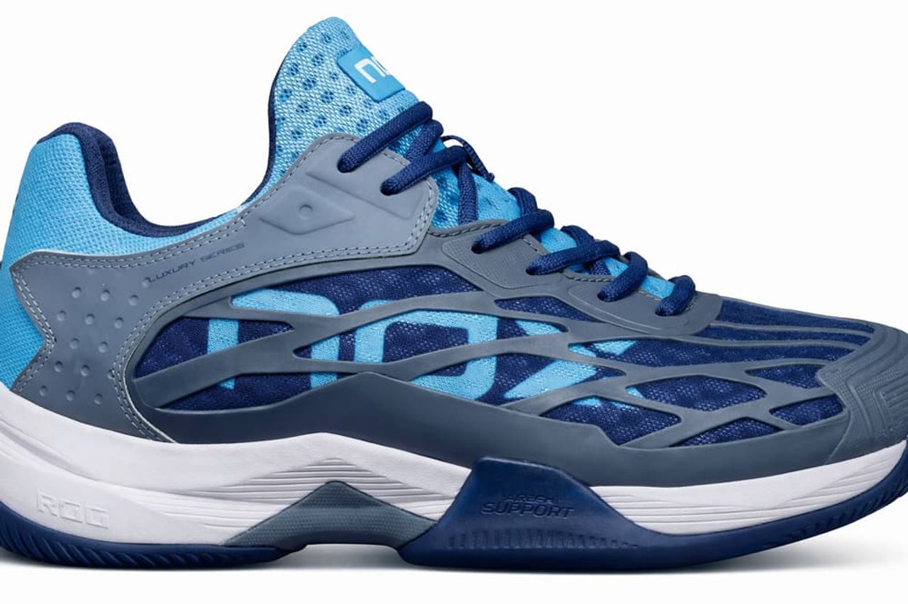 NOX AT10 Lux Padel-Schuh in Blau und Grau, seitliche Ansicht mit atmungsaktivem Mesh-Obermaterial, stabilisierenden Overlays, gepolsterter Zwischensohle und rutschfester Sohle für optimalen Halt und Komfort auf dem Padelplatz.